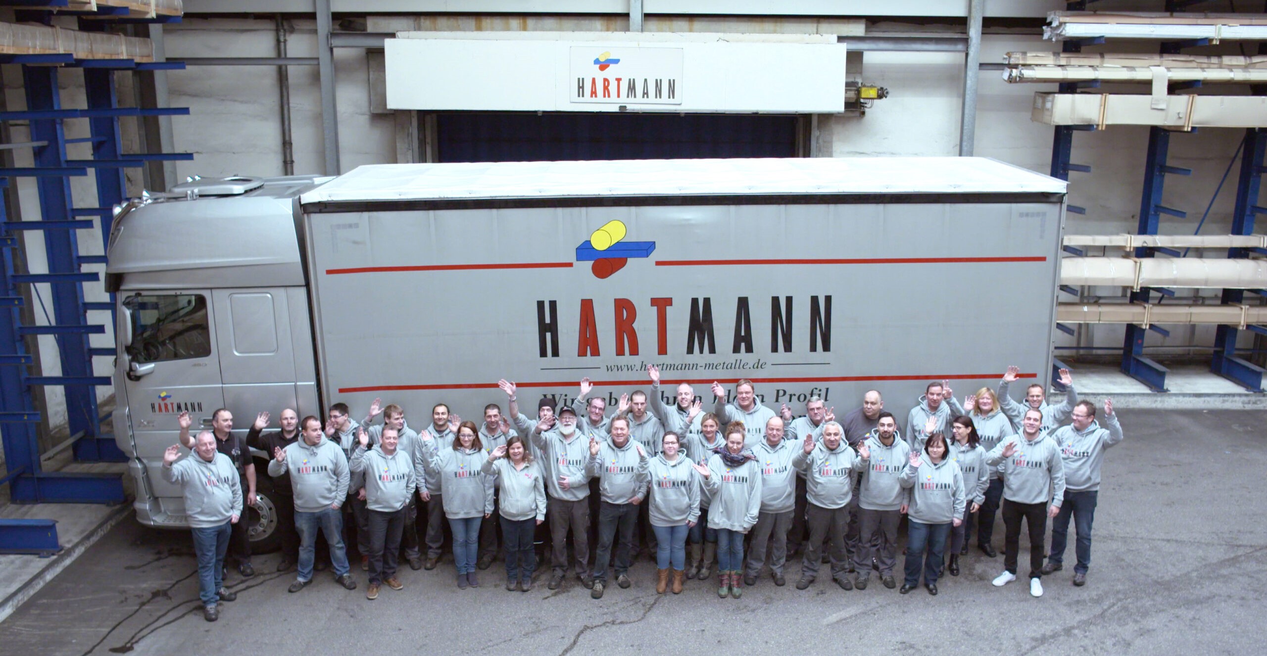 Mitarbeitende der Firma Hartmann vor einem Hartmann-LKW